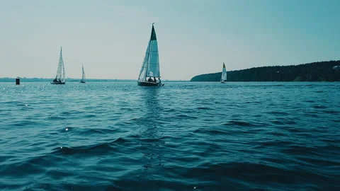 Sailing yachts against backdrop of waves, blue sea surface, clear sky. Stock Footage 160496953