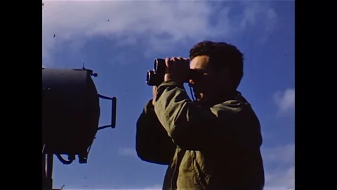 Sailor inspect through binoculars and American commanders discuss on ship - 1944 Stock Footage 98564613