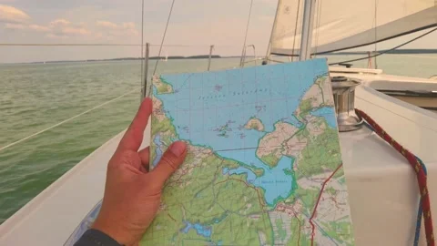 Sailor looking on the map, pointing on a certain area towards navigating ther Stock Footage 218354238