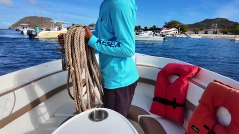 Sailor Man Pulling Anchor Rope on Boat Bow, Caribbean luxury charter, sunny Stock Footage 336374941