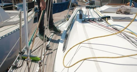 A sailor removes garbage from the deck of a sailing yacht Stock Footage 89174574