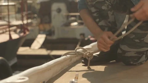 Sailor Skillfully Tying a Sea Knot on a Bright Day in Port Stock Footage 321985268