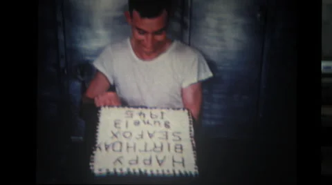 Sailor trimming cake in hand with knife Stock Footage