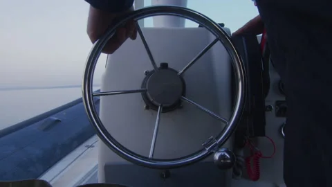 A sailor turns the wheel to navigate his boat on Lake Geneva, Switzerland Stock Footage 229680853