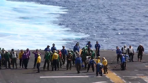 Sailors conduct a foreign object debris walk down on the flight deck - 2015 Stockbeeldmateriaal 99692655