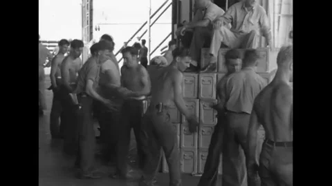 Sailors move bombshells into a cargo net aboard a warship during the Battle of Stock Footage 115803960