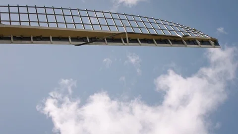 Sails of an old Dutch windmill fly by from top to bottom in front of a blue sky Stock Footage 85213967