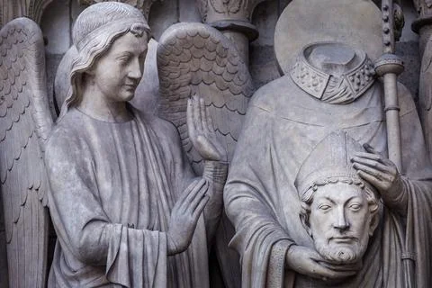 Saint Denis without head and angel, Notre dame detail in Paris, France 写真素材