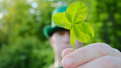 Saint Patrick. clover leaf in the hand of a man in a green hat.Four-leaf clover. Stock Footage 166024896