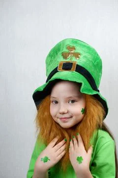 Saint Patricks Day. Endearing smiling small girl with decorative red beard 스톡 사진
