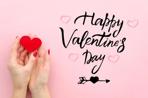 Saint Valentine concept. Flat lay female hands hold red heart and congratulation Stock Photos