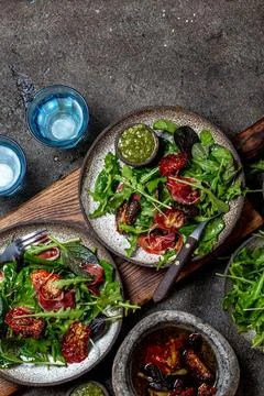 Salad with arugula, spinach, dried tomato and ham serrano paleta iberica. ... Stock Photos
