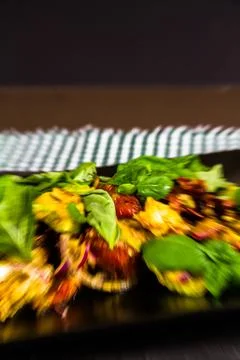 Salad with avocado, sun dried tomato, red onion, feta and basil on plate on s Stock Photos