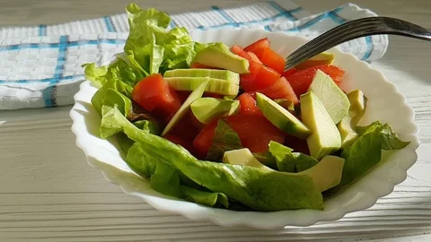 Salad with avocado tomatoes, fork Stock Footage 87608359