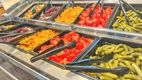 A salad bar with many different types of vegetables, including tomatoes Stock-Fotos