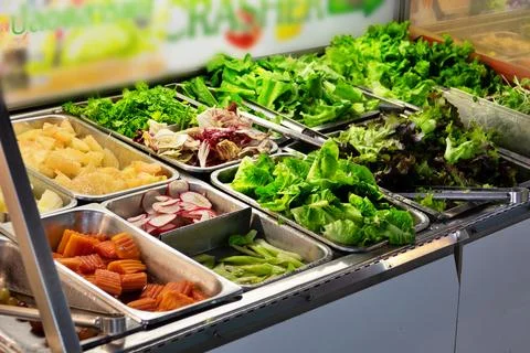A salad bar with many different types of vegetables Stock Photos