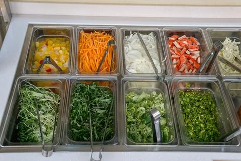 A salad bar with many different types of vegetables Stock Photos