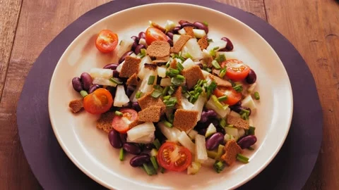Salad of beans and cherry tomatoes with pineapple and croutons on a beige plate Stock Footage 171681221