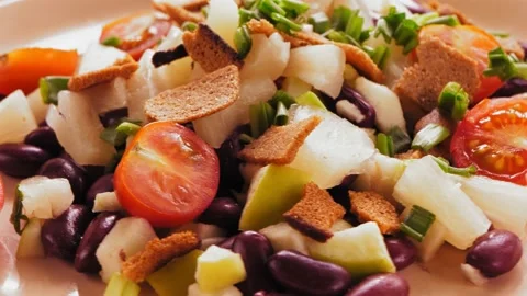 Salad of beans and cherry tomatoes with pineapple and croutons on a beige plate 库存影片 172216779