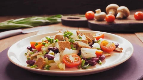 Salad of beans and cherry tomatoes with pineapple and crackers on a beige plate  Stock Footage 172216967