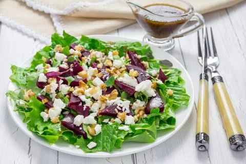 Salad with beets, feta cheese and walnuts, dressed with balsamic sauce Foto stock