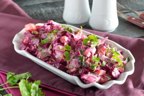 Salad with boiled beetroot, potato, pickles, onions in a white plate Stock Photos