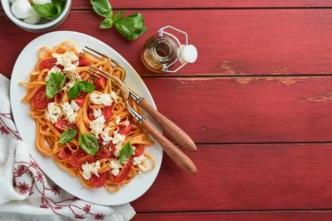 Salad caprese or pasta spaghetti broken with basil and mozzarella ala capre.. Stock Photos