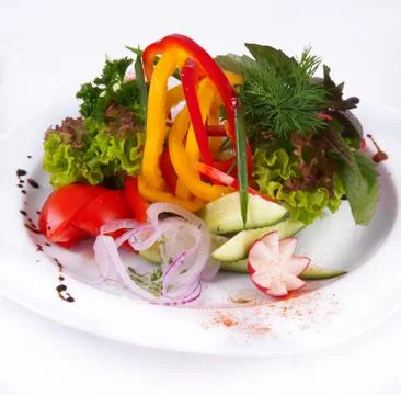 Salad with different vegetables on a plate on a white background Stock Photos