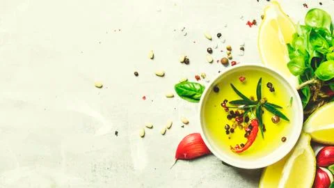 Salad dressing with basil, olive oil, garlic, lemon and spices, top view, foo Stock Photos
