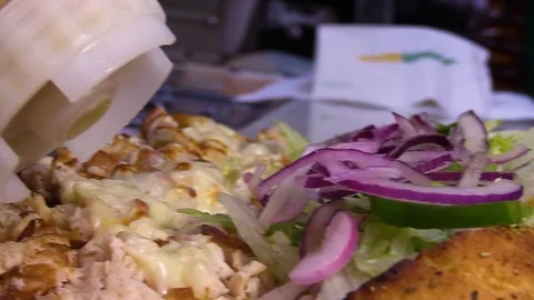 Salad dressing poured on a sub sandwich Vidéo 105983633