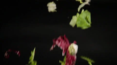 Salad falls onto a plate in slow motion Stock Footage 331882369