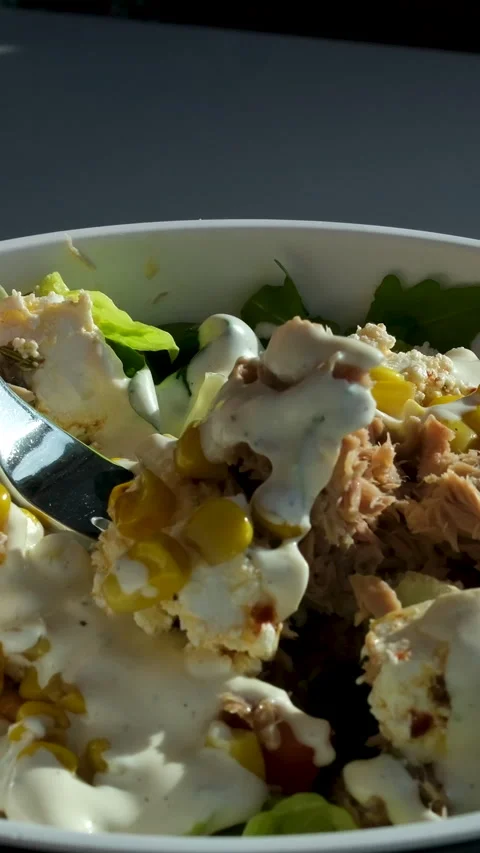 Salad fork dressing Bowl with salad with tuna, corn, parmesan cheese, tomatoes Stock Footage 314097651
