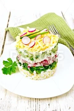 Salad layered with radish and cucumber on light board Stock Photos