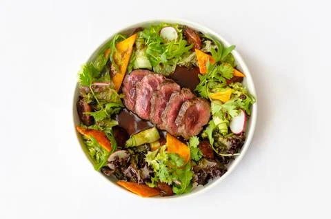Salad with medium roasted beef and greens on a white background Stock Photos