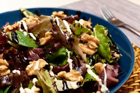 Salad with a mixture of lettuce, walnuts, extra virgin olive oil, balsamic vi Stock Photos