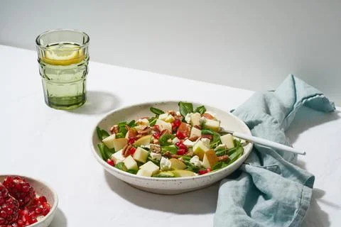 Salad with nuts. Spinach with apples, pecans and feta. Hard light, shadows, side Stock Photos