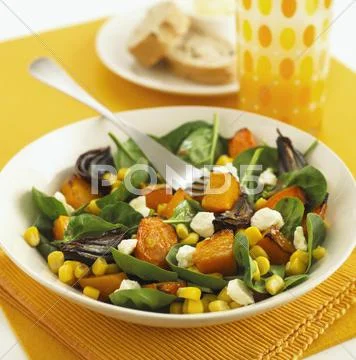 Salad with roasted diced squash, lamb's lettuce, sweetcorn and feta Stock Photos