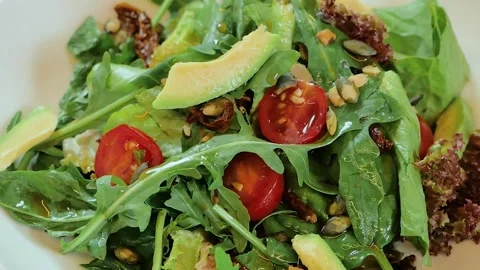 Salad rotates on a white plate Stock Footage 253189414