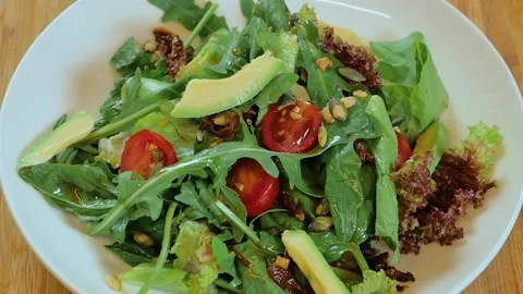 Salad rotates on a white plate: Stock Footage 253190408