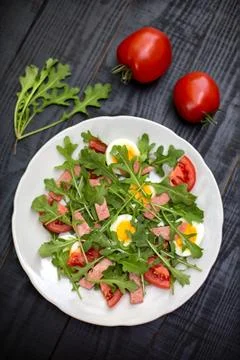 Salad with rucola, tomato, eggs and ham Stock Photos