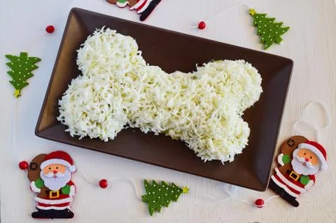 Salad in the shape of a bone made of chicken, pineapple, cheese, egg,, mushrooms Stock Photos