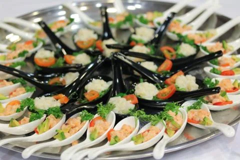 Salad snacks in ceramic spoons at the stand-up party or buffet lunch Stock Photos