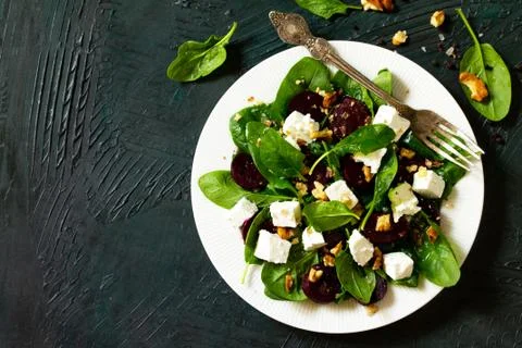 Salad with spinach, feta cheese, beetroot and walnut, vegetable oil sauce. Stock Photos