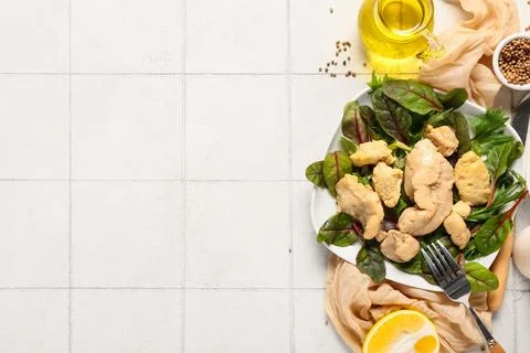 Salad with tasty cod liver and herbs on beige tile background Stock Photos