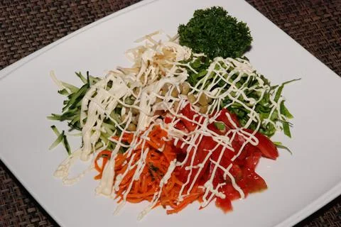 Salad under the layer of mayonese on the white plate Stock Photos