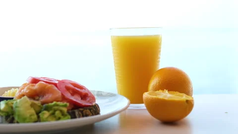 Salad vegetables pouring orange grapefruit juice from juicer into glass on Video stock 317715577