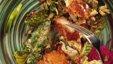 Salad with warm breaded chicken, meat fillet, eating with a fork, top view. Stock Footage 204687453