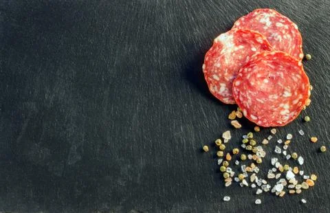 Salami on dark background Stock Photos