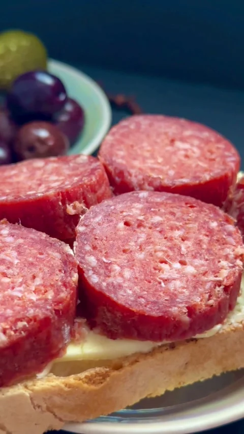 Salami sandwich with butter on bread with side olives Stock Footage 331974742