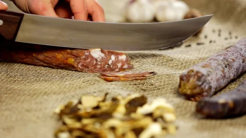 Salami sausage is being cut to thin slices Stock Footage 102586245